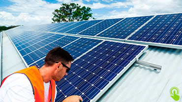 Men installing solar PV panels on a roof